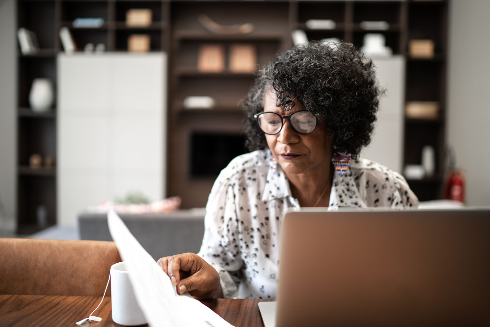 Female business owner working at her desk with computer and paper